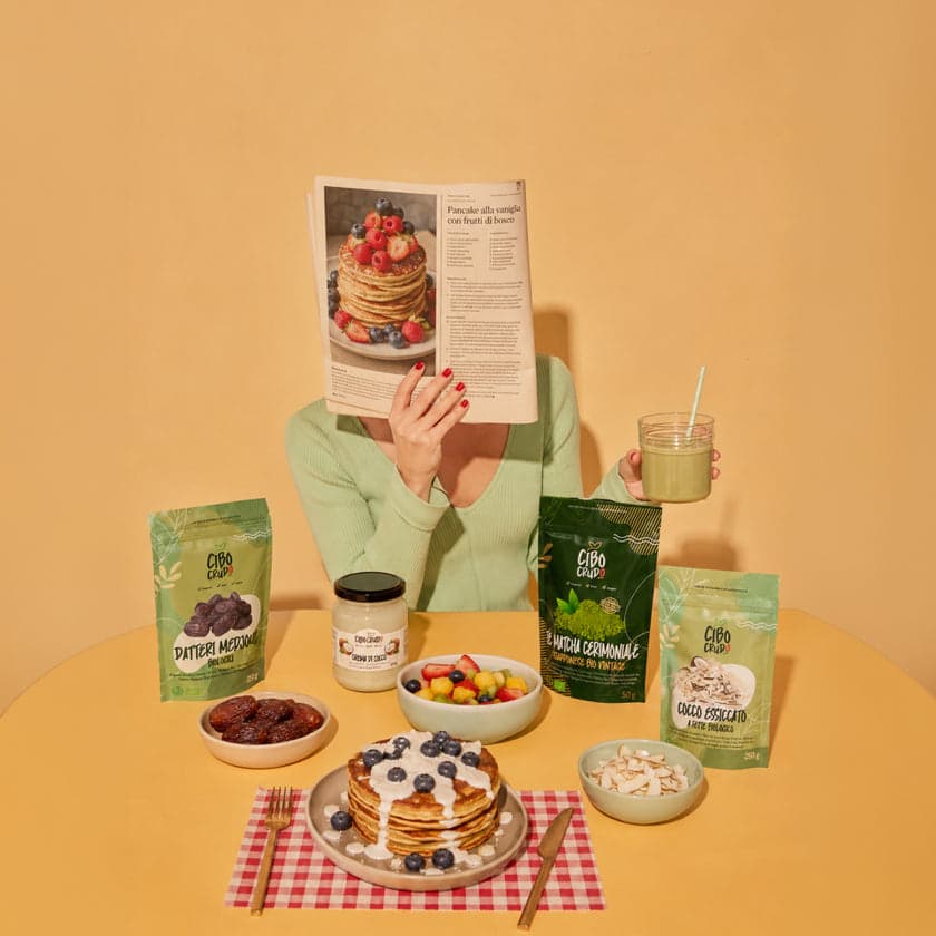 CiboCrudo packages of dates, cashew butter, matcha and coconut arranged on a breakfast table