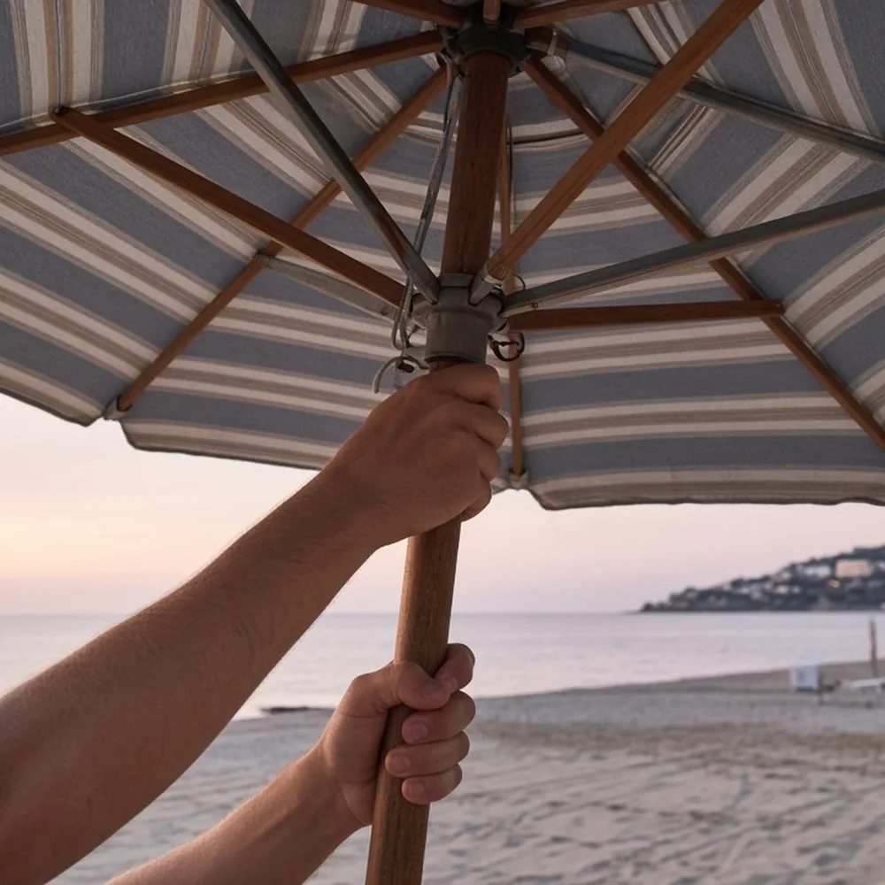 Mani che sistemano gli ombrelloni in spiaggia la mattina presto