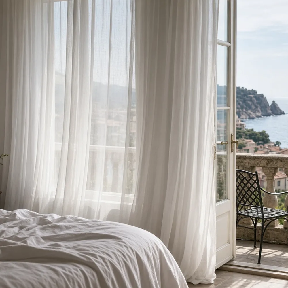 Una camera con balcone e vista mare, tende bianche